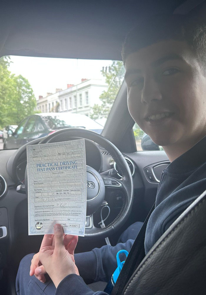 Learner holding a practical driving test pass certificate after passing