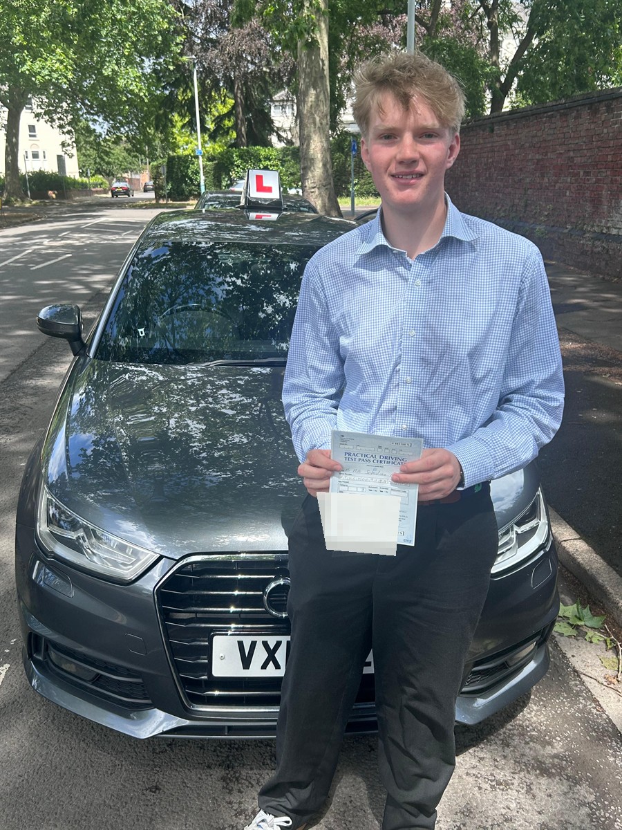 Learner holding a practical driving test pass certificate beside an A2Z Drive tuition car